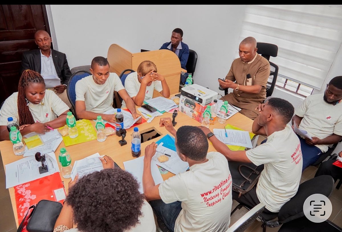Diverse people gathered around a large wooden table participating in a creative workshop