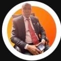 Professional portrait of a man in business attire against an orange circular background