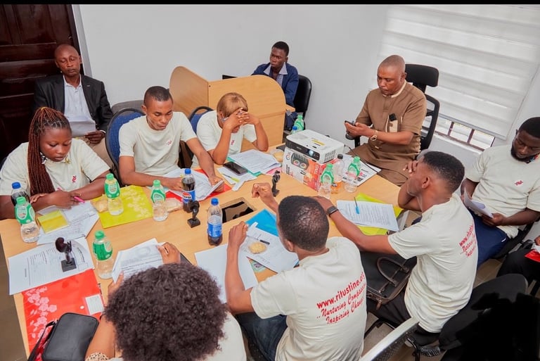 Group of diverse people collaborating around a table with art supplies, notebooks, and creative materials during a workshop or team activity